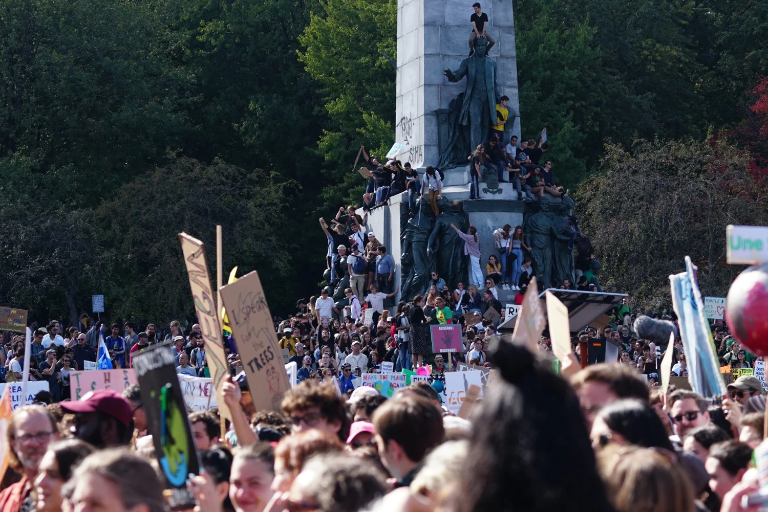 Une foule dense brandit des pancartes pour le climat autour du monument à George-Étienne Cartier, à Montréal.